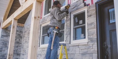 Builder tiling facade of house